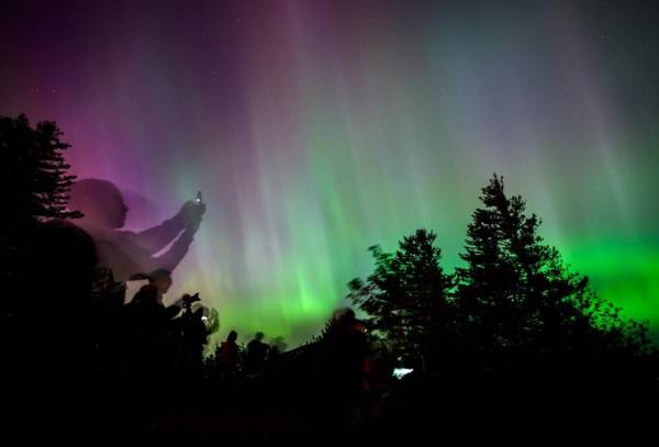 <i>Los espectadores contemplan y fotografían la aurora boreal en el mirador Chanticleer Point en la garganta del río Columbia en las primeras horas de la mañana del 11 de mayo de 2024 en Latourell, Oregón. FOTO Mathieu Lewis-Rolland/Getty Images/AFPMathieu Lewis-Rolland / GETTY IMAGES NORTEAMÉRICA / Getty Images vía AFP</i>