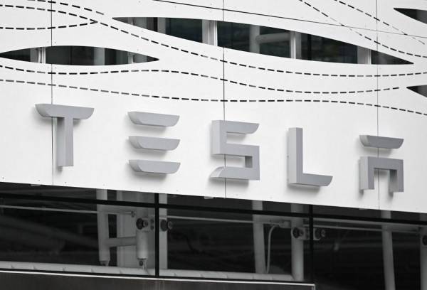 <i>(ARCHIVOS) El logotipo de Tesla se ve en la tienda Santa Monica Place en Santa Mónica, California, el 20 de marzo de 2023. Tesla planea despedir a más del 10 por ciento de su fuerza laboral global, informó el sitio de noticias Electrek el 15 de abril. 2024, publicación de un correo electrónico del director ejecutivo, Elon Musk, anunciando los recortes.FOTO Patrick T. Fallon / AFP</i>