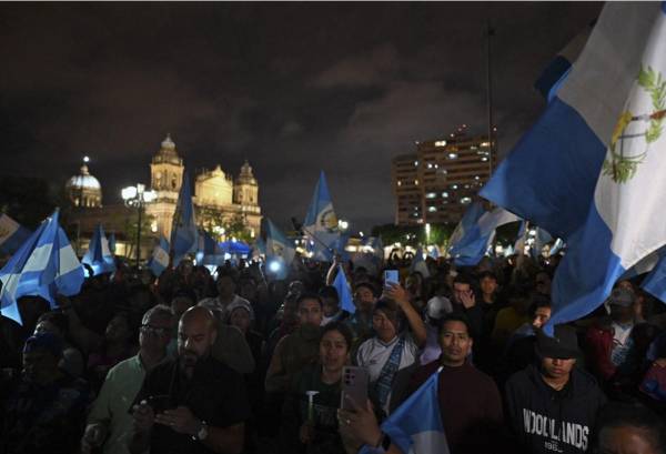 <i>Los manifestantes realizan una protesta para exigir la renuncia de la Fiscal General Consuelo Porras y del fiscal Rafael Curruchiche frente al Palacio de la Cultura en la Ciudad de Guatemala, el 7 de octubre de 2023. FOTO JOHAN ORDONEZ / AFP</i>