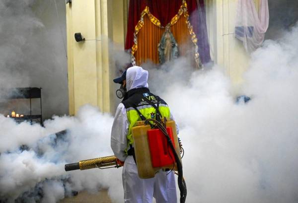 <i>Un trabajador municipal fumiga contra el mosquito Aedes aegypti, vector de los virus del dengue, Zika y Chikungunya, como medida preventiva en la Iglesia Las Misericordias en la Ciudad de Guatemala el 30 de agosto de 2023. FOTO JOHAN ORDONEZ / AFP</i>