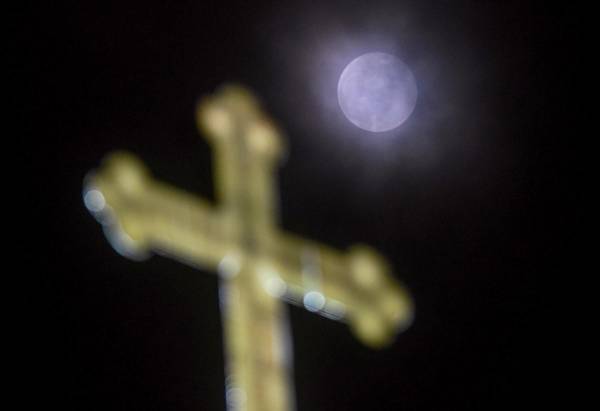 <i>Esta fotografía tomada el 25 de marzo de 2024 muestra una Luna Llena sobre una cruz en la Iglesia de San Juan Bautista en Skopje. FOTO Robert ATANASOVSKI / AFP</i>