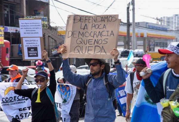 <i>Estudiantes universitarios y miembros de la sociedad civil participan en una manifestación para exigir la renuncia de la fiscal general Consuelo Porras, el fiscal anticorrupción Rafael Curruchiche y otros funcionarios judiciales acusados de generar una crisis electoral en la Ciudad de Guatemala el 18 de noviembre de 2023. FOTO ORLANDO ESTRADA / AFP</i>