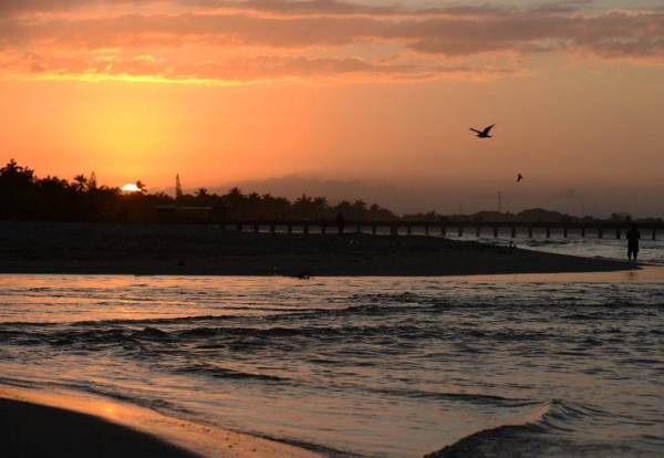 <i>Atardecer en el puerto de Tela, 250 kilómetros al norte de Tegucigalpa. FOTO ORLANDO SIERRA/AFP</i>