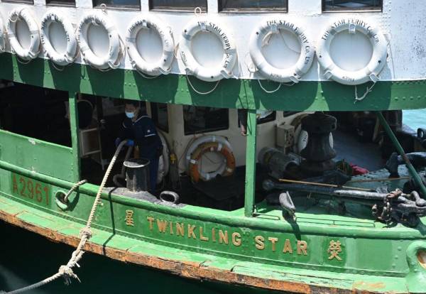 <i>Un Star Ferry atraca en Tsim Sha Tsui en el puerto Victoria de Hong Kong el 4 de mayo de 2022. Ha tenido dificultades financieras para mantenerse a flote después de que las llegadas de turistas a la ciudad del sur de China se desplomaran debido a las protestas de 2019 y las agobiantes restricciones de viaje impuestas debido al Covid-19. FOTO Pedro PARQUES / AFP</i>