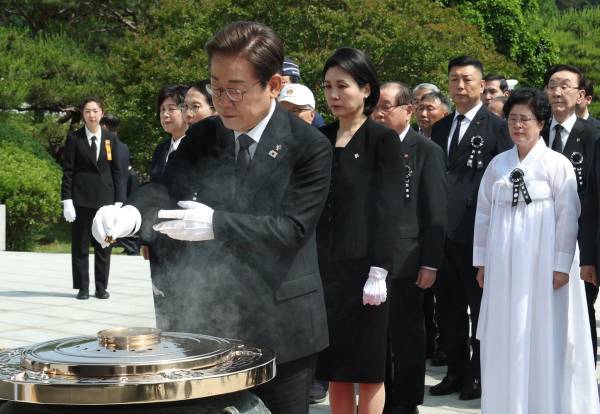 <i>El presidente de Corea del Sur, Lee Jae-myung (al frente), y la primera dama, Kim Hye-kyung (detrás de Lee), presentan sus respetos a la Torre Memorial durante un evento conmemorativo por el Día de los Caídos en el Cementerio Nacional de Seúl, en Seúl, Corea del Sur. EFE/EPA/YONHAP</i>