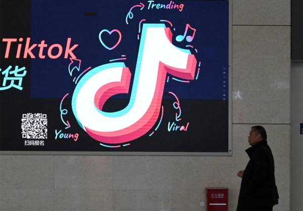 <i>Un hombre pasa junto a un anuncio con el logotipo de TikTok en una estación de tren en Zhengzhou, en la provincia central de Henan, China, el 21 de enero de 2024. FOTO GREG BAKER/AFP</i>