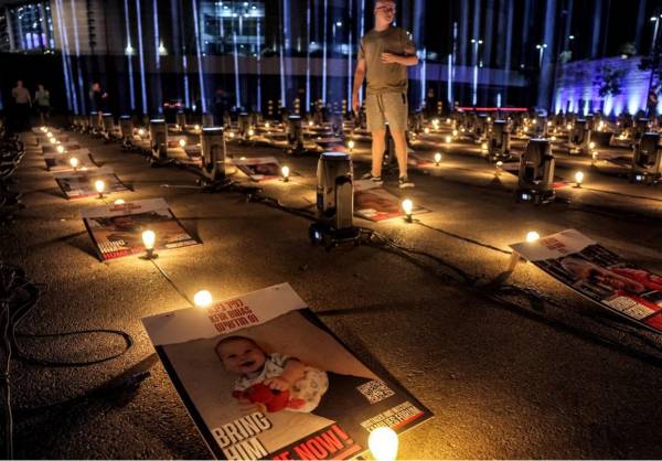 <i>Un hombre se encuentra entre carteles de rehenes secuestrados por militantes palestinos durante el ataque del 7 de octubre y actualmente retenidos en la Franja de Gaza, colocados junto a bombillas y focos como parte de una instalación que consta de 224 pilares de luz erigidos por la municipalidad de Jerusalén como homenaje a Los rehenes fueron capturados frente al estadio Teddy de Jerusalén el 26 de octubre de 2023. FOTO AHMAD GHARABLI / AFP</i>