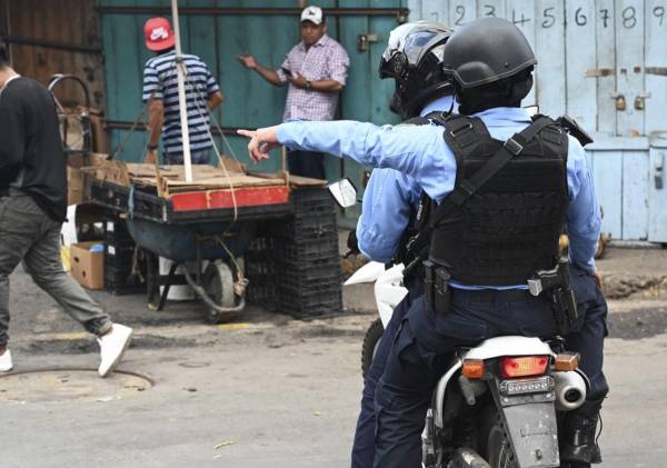 <i>Miembros de la Policía Nacional de Honduras participan en un operativo de seguridad llamado Mercados Seguros en Tegucigalpa el 14 de julio de 2023. FOTO ORLANDO SIERRA / AFP</i>