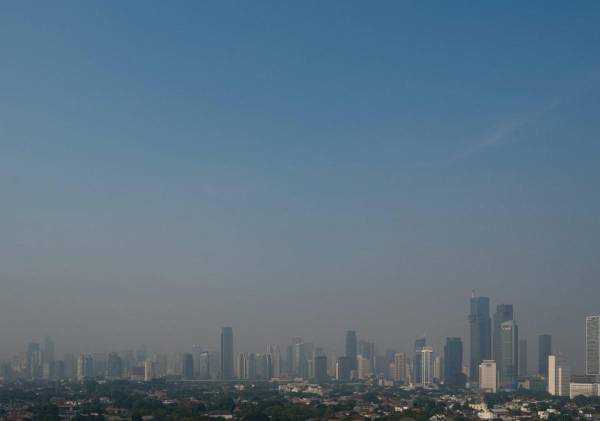 <i>Los edificios se ven en la neblina causada por la contaminación del aire en Yakarta el 25 de agosto de 2023. La megalópolis de unos 30 millones de habitantes ha visto cómo los niveles de contaminación del aire se han elevado a algunos de los más altos del mundo en los últimos meses, encabezando las clasificaciones mundiales varias veces desde el principios de agosto, según el monitor suizo del aire IQAir. Yasuyoshi CHIBA/AFP</i>