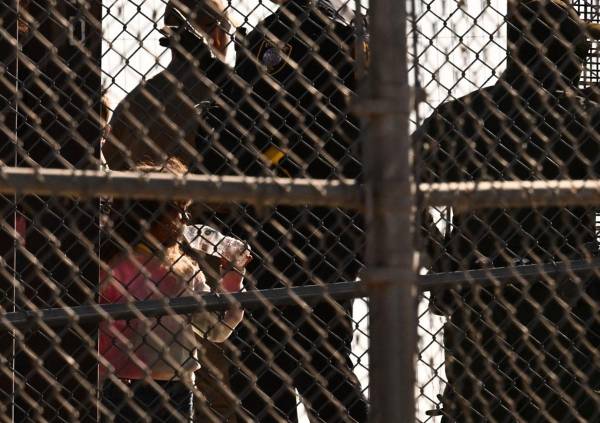 <i>Un niño bebe de una botella de agua mientras los migrantes abordan las camionetas de la Patrulla Fronteriza después de esperar a lo largo del muro fronterizo para entregarse a los agentes de Aduanas y Protección Fronteriza (CBP) de los Estados Unidos para procesar las solicitudes de inmigración y asilo al cruzar el río Grande hacia los Estados Unidos en el Frontera entre Estados Unidos y México en El Paso, Texas, el 11 de mayo de 2023. Estados Unidos el 11 de mayo de 2023 oficialmente. PATRICK T. FALLON / AFP</i>