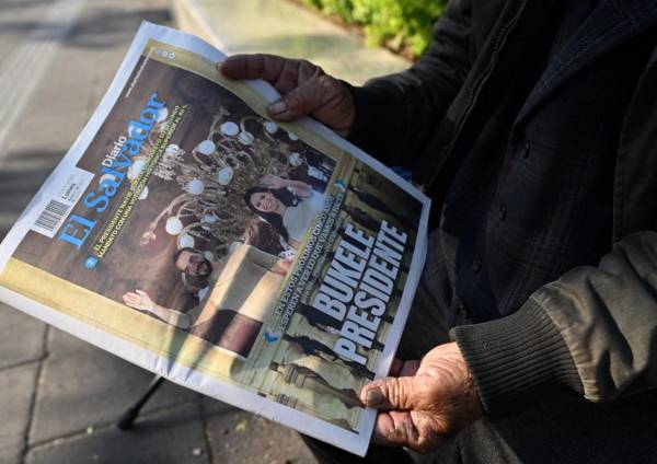 <i>Un hombre muestra un periódico con la portada que dice Presidente Bukele en el centro histórico de San Salvador el 5 de febrero de 2024. FOTO Marvin RECINOS / AFP</i>