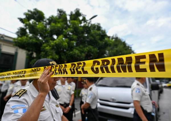 <i>Policías acordonan el ingreso a la sede del Tribunal Supremo Electoral mientras fiscales del Ministerio Público realizan un allanamiento en Ciudad de Guatemala el 29 de septiembre de 2023. FOTO JOHAN ORDONEZ / AFP</i>