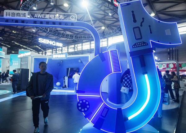 <i>Un hombre pasa por un stand de Tiktok durante la Exposición Mundial de Electrodomésticos y Electrónica (AWE) en Shanghai el 14 de marzo de 2024. FOTO STR/AFP</i>