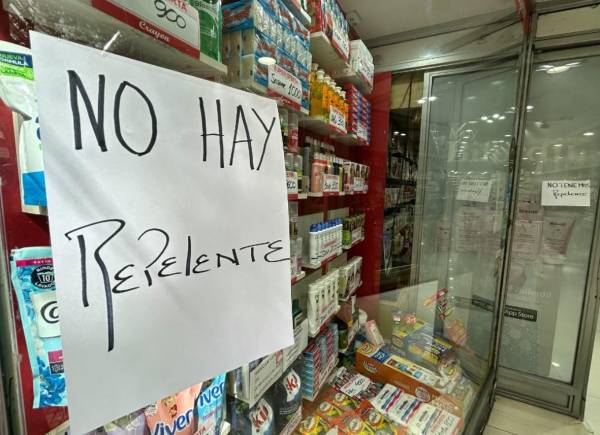 <i>Un cartel que dice 'No hay repelente disponible' se muestra en el escaparate de una tienda en Buenos Aires el 2 de abril de 2024, mientras Argentina enfrenta un número significativo y creciente de casos de dengue. FOTO Juan Mabromata/AFP</i>