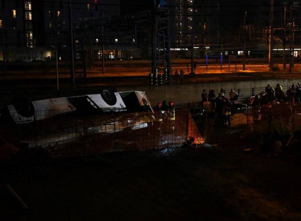 <i>Los bomberos trabajan en el lugar de un accidente de autobús el 3 de octubre de 2023 en Mestre, cerca de Venecia. El autobús se incendió después de caer de un puente que une los distritos de Mestre y Marghera. FOTO MARCO SABADÍN / AFP</i>