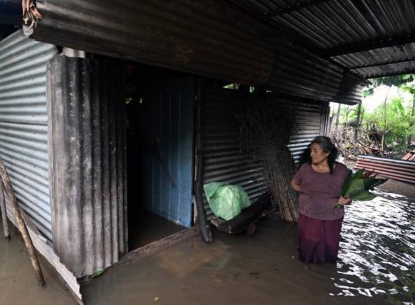 <i>Una mujer es vista en su casa inundada después del paso de la tormenta tropical Pilar en la aldea de Los Ángeles, en Zacatecoluca, El Salvador, el 1 de noviembre de 2023. FOTO MARVIN RECINOS / AFP</i>