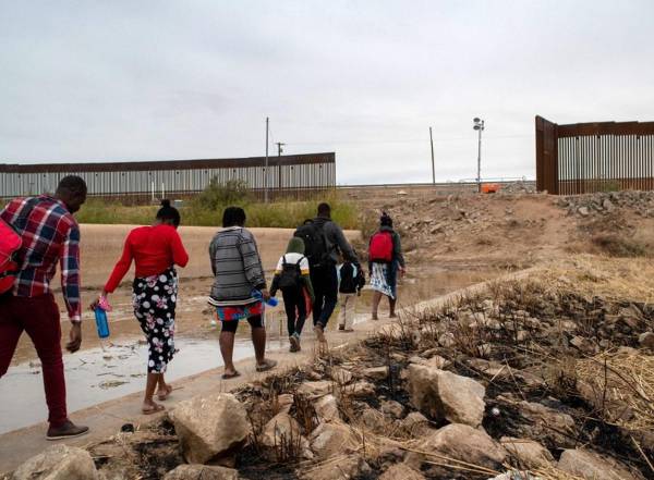 <i>ARCHIVO. Familias haitianas caminan a través de una brecha en el muro fronterizo entre Estados Unidos y México el 7 de diciembre de 2021 hacia Yuma, Arizona. En muchos casos, los funcionarios de inmigración mexicanos permiten a las familias migrantes con madres embarazadas, consideradas altamente vulnerables, dirigirse a la frontera de Estados Unidos, donde pueden solicitar asilo. FOTO John Moore/Getty Imagesvía AFP</i>