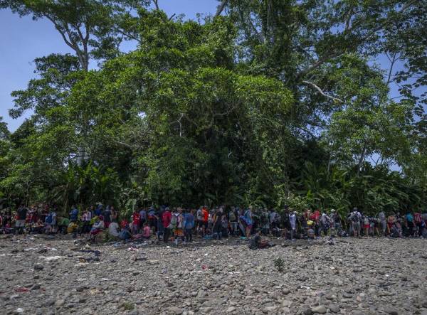<i>Migrantes descansan bajo la sombra de un árbol cerca de la aldea de Bajo Chiquito, el primer control fronterizo de la provincia de Darién en Panamá, el 22 de septiembre de 2023. FOTO Luis ACOSTA/AFP</i>