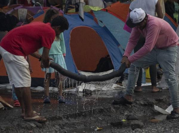 Migrantes estrujan una toalla en un refugio improvisado en Paso Canoas, a unos 300 km al sur de San José, en la provincia de Puntarenas, Costa Rica, el 26 de septiembre de 2023. Cada día llega un flujo cada vez mayor de migrantes a la ciudad de Paso Canoas. , el principal paso fronterizo entre Panamá y Costa Rica, golpeado tras cruzar la selva del Darién en su camino hacia Estados Unidos.