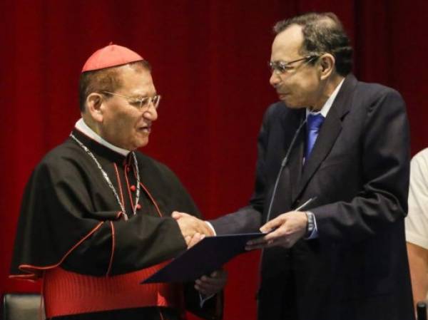 El cardenal emérito Miguel Obando y Bravo (izq.) es decorado con el premio 'Héroe de la Paz' del presidente del Congreso, René Nuñez, el 10 de marzo de 2016. AFP PHOTO/ Inti OCON / AFP PHOTO / Inti Ocon