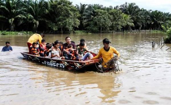 Personas afectadas por inundaciones tras el paso de la Tormenta Tropical Julia, son evacuadas en lancha, en el municipio de Choloma, departamento de Cortés, Honduras, el 10 de octubre de 2022. ( FOTO Wendell ESCOTO / AFP)