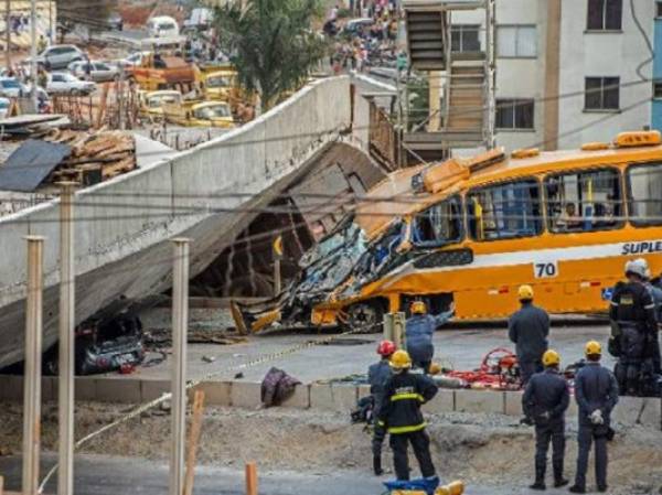 Bomberos y policías trabajan en el lugar del derrumbe de un viaducto en construcción. (Foto: AFP).