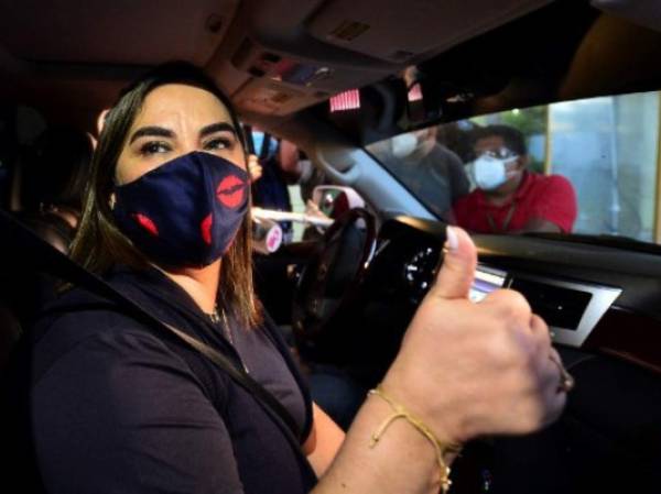 Honduran former first lady (2010-2014) Rosa Elena Bonilla, wife of Honduran former president Porfirio Lobo, gives the thumb up as she gets on a car after being freed in Tamara, 20 km north of Tegucigalpa, on July 23, 2020. - Bonilla, who had been convicted on corruption charges, was released from preventive detention Thursday and will face another trial. (Photo by ORLANDO SIERRA / AFP)