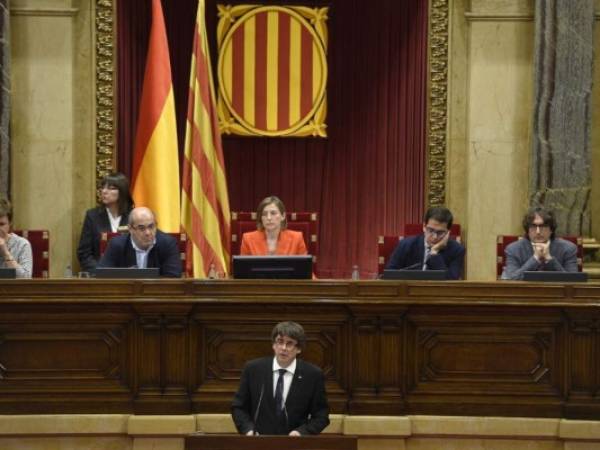 Catalan regional government president Carles Puigdemont (C) gives a speech at the Catalan regional parliament in Barcelona on October 10, 2017.Spain's worst political crisis in a generation will come to a head as Catalonia's leader could declare independence from Madrid in a move likely to send shockwaves through Europe. / AFP PHOTO / LLUIS GENE