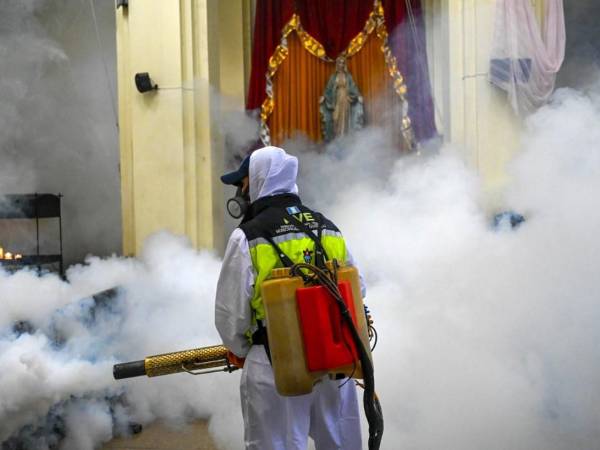 <i>Un trabajador municipal fumiga contra el mosquito Aedes aegypti, vector de los virus del dengue, Zika y Chikungunya, como medida preventiva en la Iglesia Las Misericordias en la Ciudad de Guatemala el 30 de agosto de 2023. FOTO JOHAN ORDONEZ / AFP</i>