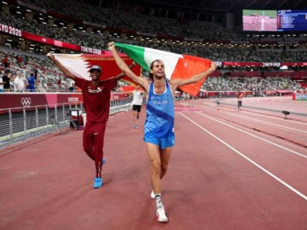 Gold medalist Mutaz Essa Barshim (L) of Team Qatar and silver medalist Gianmarco Tamberi of Team Italy celebrate on the track following the Men's High Jump Final during the Tokyo 2020 Olympic Games at the Olympic Stadium in Tokyo on August 1, 2021. (Photo by Christian Petersen / POOL / AFP)