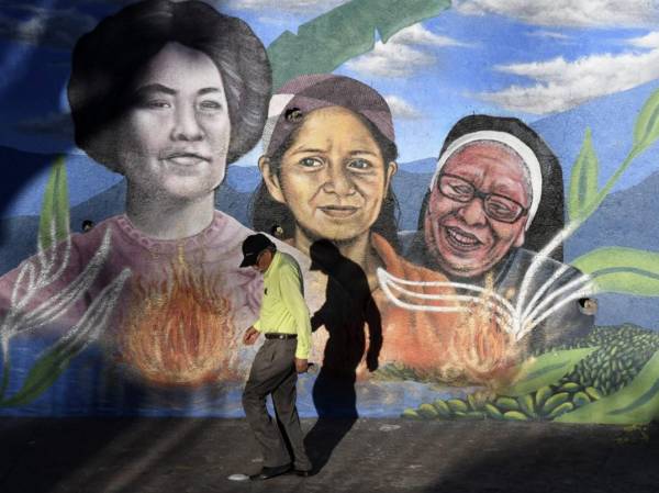 <i>Un hombre pasa junto a un mural en una avenida central de Tegucigalpa el 8 de febrero de 2024. La capital hondureña se ha convertido en una galería al aire libre, donde artistas locales dan color y vida a este antiguo pueblo minero. FOTO Orlando SIERRA/AFP</i>