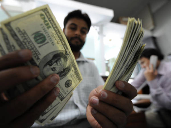 TO GO WITH 'Pakistan-UAE-Gulf-economy-remittances,FOCUS' by Hasan MansoorA Pakistani money dealer counts US dollars notes at a money market in Islamabad on April 20, 2009. Pakistani expatriate workers wired home a record 739.4 million dollars last month, but experts warn job losses abroad and the global credit crunch could soon slash remittances and haunt the economy. The March remittances from Pakistanis working overseas surpassed the previous monthly record of 673.5 million dollars last December. AFP PHOTO / Aamir QURESHI (Photo credit should read AAMIR QURESHI/AFP/Getty Images)