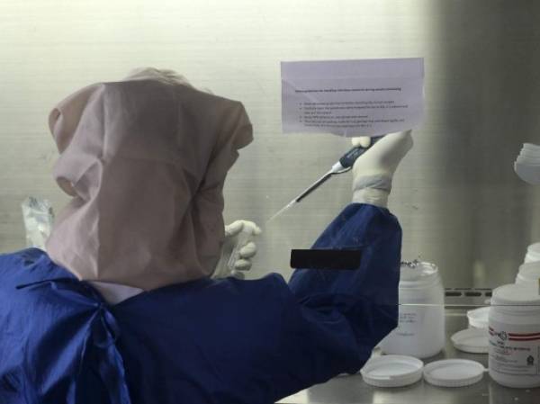 A healthcare worker conducts Polymerase Chain Reaction (PCR) tests in a microbiology lab at the Kotelawala Defence University Hospital (KDU) during a government-imposed nationwide lockdown as a preventive measure against the COVID-19 coronavirus, in Colombo on April 24, 2020. - The do-it-yourself distilling in Sri Lanka after the country announced a total ban on alcohol has caused a run on sugar, a key ingredient in producing the local moonshine known as kasippu. The goods missing from stores reveal how the world is coping with coronavirus lockdowns. (Photo by LAKRUWAN WANNIARACHCHI / AFP)