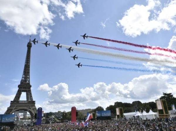 La patrulla aérea francesa 'Patrouille de France' sobrevuela la aldea de fans de El Trocadero frente a la Torre Eiffel, en París, el 8 de agosto de 2021 tras la transmisión de la ceremonia de clausura de los Juegos Olímpicos de Tokio 2020. (Foto de STEPHANE DE SAKUTIN / AFP)