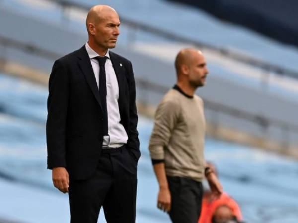Real Madrid's French coach Zinedine Zidane (L) and Manchester City's Spanish manager Pep Guardiola watch the players from the touchline during the UEFA Champions League round of 16 second leg football match between Manchester City and Real Madrid at the Etihad Stadium in Manchester, north west England on August 7, 2020. (Photo by Shaun Botterill / POOL / AFP)