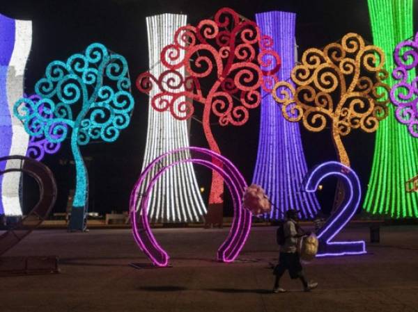 A cotton candy vendor walks amid Christmas decorations at the Juan Pablo II Square in Managua on December 17, 2020. (Photo by INTI OCON / AFP)