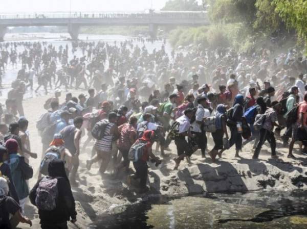 Central American migrants - mostly Hondurans travelling in caravan to the US- cross the Suchiate River, the natural border between , Guatemala, with Ciudad Hidalgo, Mexico, on January 20, 2020. - Hundreds of Central Americans from a new migrant caravan tried to enter Mexico by force Monday by crossing the river that divides the country from Guatemala, prompting the National Guard to fire tear gas, an AFP correspondent said. (Photo by Johan ORDONEZ / AFP)