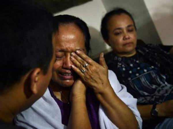 Algunos familiares de las personas que viajaban a bordo del avión de Malaysia Airlines derribado en Ucrania lloran su pérdida en Yakarta, el 18 de julio de 2014. (Foto: AFP)