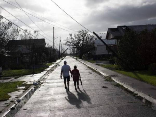 Una pareja camina en Montegut, Louisiana tras el paso del huracán Ida. Al menos dos personas han muerto tras el derrumbe de una de las principales autopistas que unen Luisiana y Misisipi, los dos Estados más golpeados por las tormentas que ha descargado el huracán Ida (Photo by Mark Felix / AFP)