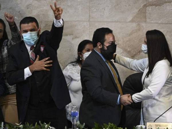 Luis Redondo (2-R), elected-President of the Congress of the Republic's Board of Directors, is greeted by deputies of the Libertad y Refundacion (LIBRE) party, at the installation of the first Legislature 2022-2026, in Tegucigalpa, on January 25, 2022. (Photo by Orlando SIERRA / AFP)