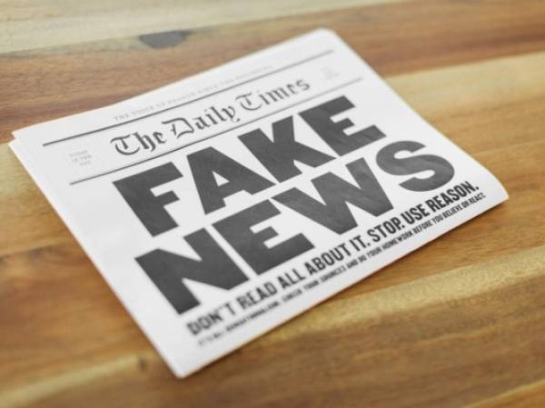 A newspaper publication with the headline Fake News sits folding on a kitchen table. Is the media presenting all the sides of the news story?