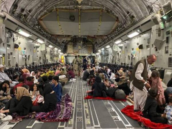 Afghan people sit inside a U S military aircraft to leave Afghanistan, at the military airport in Kabul on August 19, 2021 after Taliban's military takeover of Afghanistan. (Photo by Shakib RAHMANI / AFP)