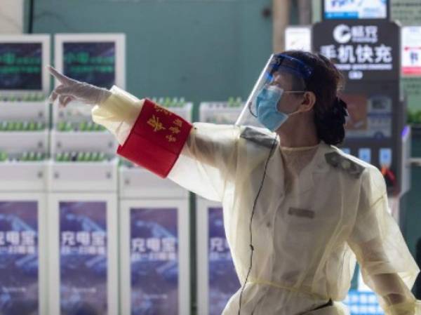 Una empleada de la estación de bus de Wuhan en China. (Foto AFP)