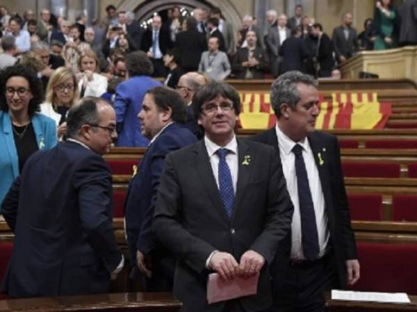 Cerca de 1.700 empresas, entre ellas los dos principales bancos de la región, CaixaBank y Sabadell, han decidido trasladar su sede social fuera de la región, en apenas dos semana. El presidente de Cataluña, Carles Puigdemont, sonríe tras la votación. (Foto: AFP).