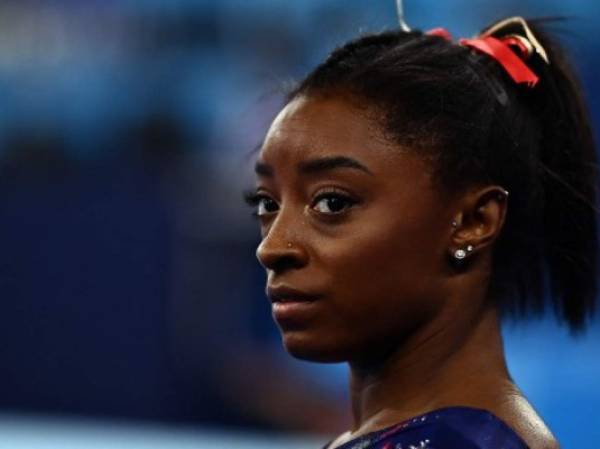 El intento de Simone Biles de conseguir su primera medalla de oro olímpica terminó después de una sola rotación tras verse obligada a retirarse de la final por equipos por un “problema médico”. (Photo by Loic VENANCE / AFP)