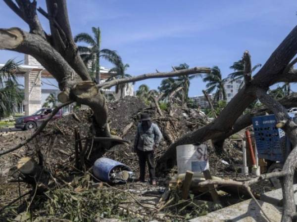 A man attempts to remove fallen trees after the passage of Hurricane Delta in Cancun, Quintana Roo state, Mexico, on October 8, 2020. - Hurricane Delta regained strength as it headed towards the United States early Thursday after lashing Mexico's Caribbean coast, where some tourists complained about conditions in crowded emergency shelters during a pandemic. (Photo by PEDRO PARDO / AFP)