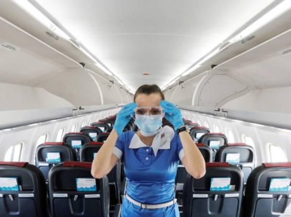 A stewardess of Ukraine's Windrose Airlines adjusts protective glasses prior to the departure for Odesa inside an ATR 72-600 passenger plane operating its first flight at the Boryspil International Airport outside Kyiv, Ukraine June 27, 2020. REUTERS/Valentyn Ogirenko - RC2OHH95QG5E