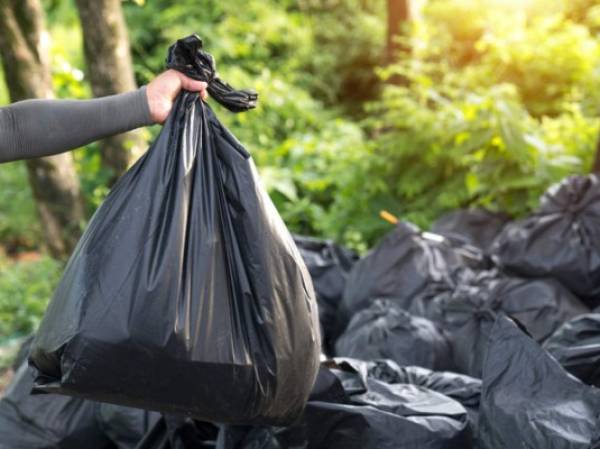 Man Taking Out Garbage In Bags