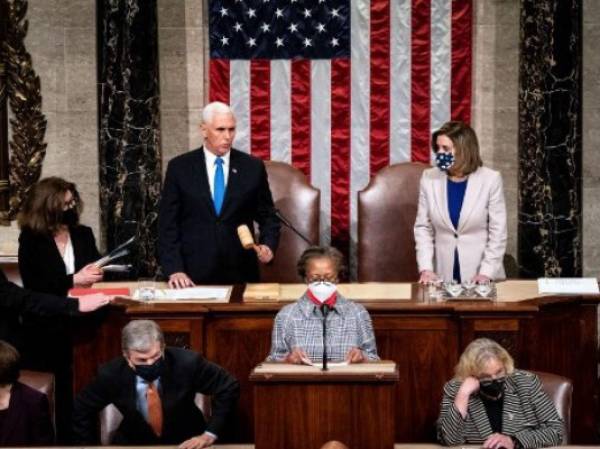 Vice President Mike Pence and House Speaker Nancy Pelosi preside over a Joint session of Congress to certify the 2020 Electoral College results after supporters of President Donald Trump stormed the Capitol earlier in the day on Capitol Hill in Washington, DC on January 6, 2020. - Members of Congress returned to the House Chamber after being evacuated when protesters stormed the Capitol and disrupted a joint session to ratify President-elect Joe Biden's 306-232 Electoral College win over President Donald Trump. (Photo by Erin Schaff / POOL / AFP)