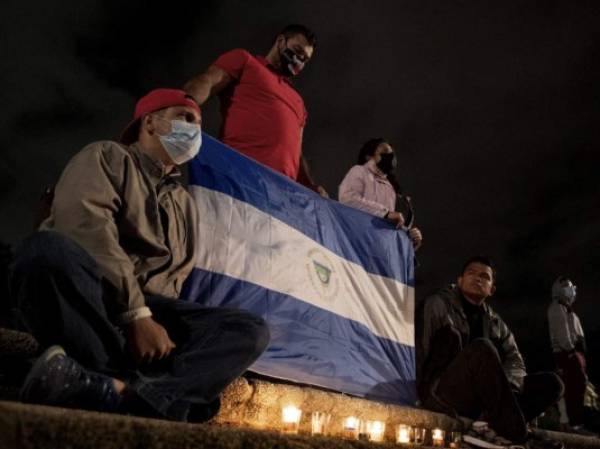 Nicaraguan exiles living in Costa Rica participate in a vigil against the Nicaraguan government and President Daniel Ortega, in San Jose, Costa Rica, January 9, 2022. - Ortega, 76, was reelected on November 7, 2021 to a fourth consecutive term with 75 percent of the vote but the result was largely rejected by the international community, including the United States and European Union. Since returning to power in 2007, he has become increasingly authoritarian and quashed presidential term limits. (Photo by Ezequiel BECERRA / AFP)